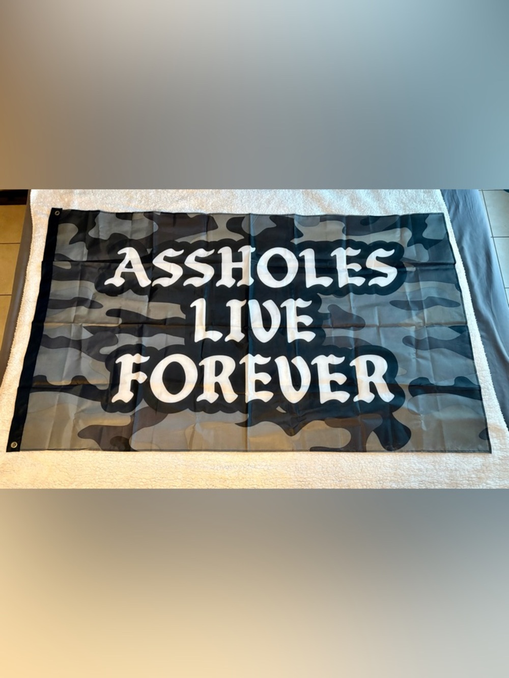 Assholes Live Forever Camo Banner with Bold White Lettering